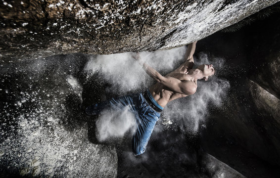 Shirtless young man climbing on mountain
