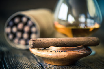 cuban cigar in ashtray on wooden table