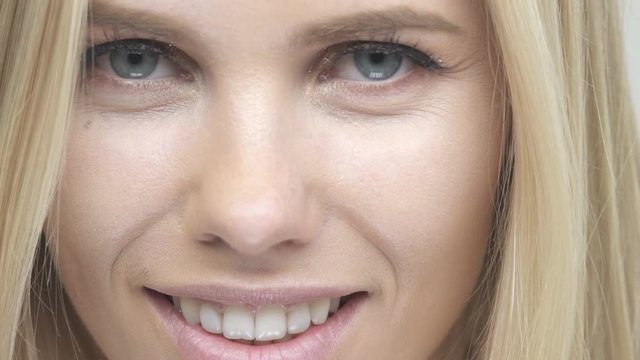 Face of smiling young beautiful blonde woman looking at camera