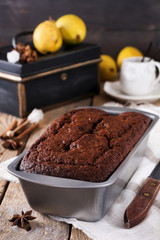 .Chocolate cake with pears and cinnamon on old wooden background. Selective focus.