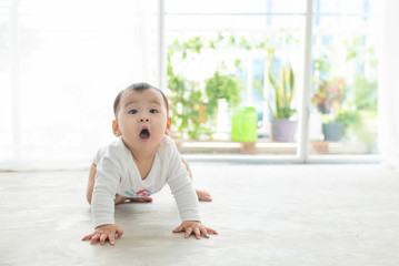 Little pretty baby girl crawling on the floor at home