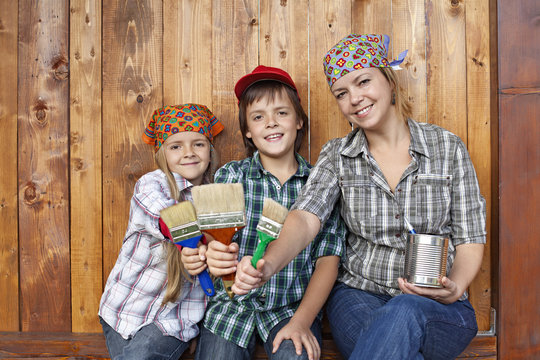 Woman with kids ready to paint the shed