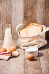 Bread, Eggs and Milk on Wooden Background.