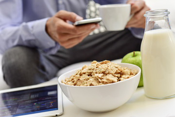 businessman checking his smartphone during the breakfast time