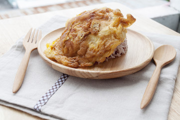 Thai omelet with brown rice on wooden dish at sunny day, selecti