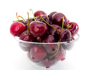 Red ripe cherry in a glass bowl isolated on the white background