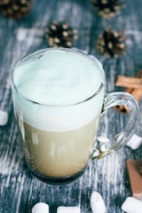 Latte with mint syrup. Glass of coffee with chocolate, cinnamon, marshmallow on wooden table