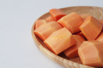 Ripe papaya slices on wooden dish, selective focus and soft focu