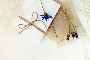 Pile of love notes on craft paper, dried lovely flowers, lace and twine bow decor. Romantic congratulation background, empty space. 