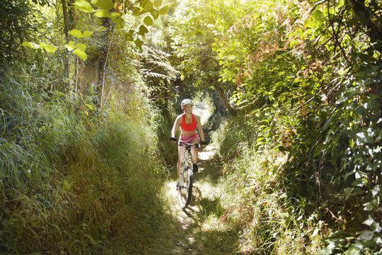 Young woman riding mountain bike on a trail