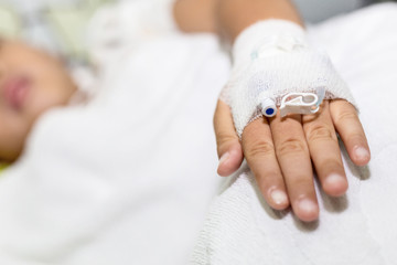 Patient child hand with saline intravenous (iv) in hospital