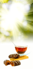 image of cups with tea and candies on sunlight background closeup