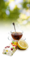 image of cups with tea and candies on sunlight background closeup