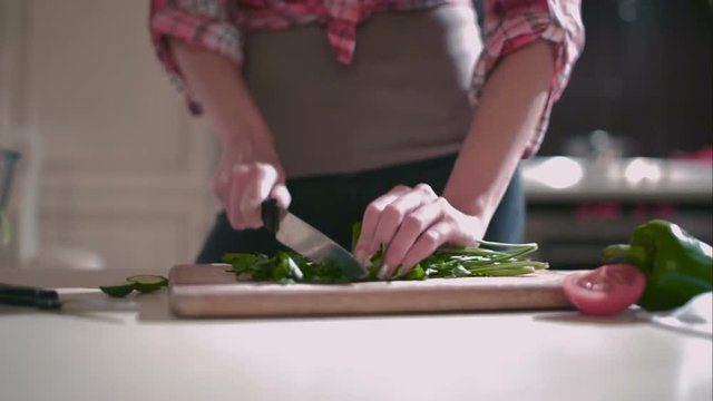 Woman chops parsley for the salad