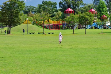 Obraz premium 夏の芝生の公園を走る少女
