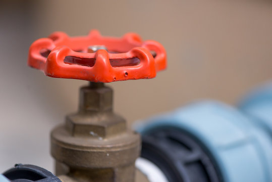 Close-up detail of a red gas valve handle, for emergency shutoffs. They are used in various factories and home plumbing systems. Industry and engineering concept.