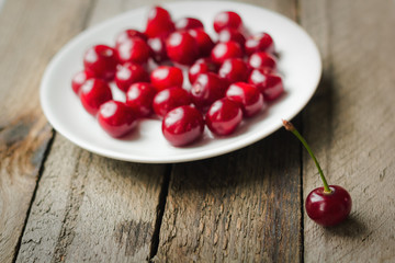 Cherries on vintage wooden table in plate