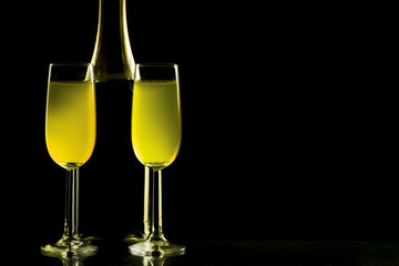 Glasses and bottle of champagne isolated on a black background