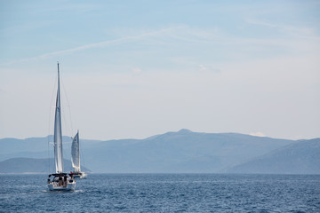 Fototapeta na wymiar Sailing boat in the adriatic ocean, Croatia. Mountains on the horizon.