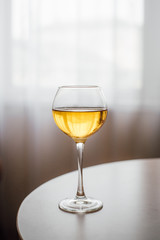 Glass of chilled white wine on wooden table