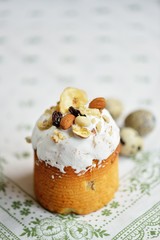 Easter holiday cake with quail eggs nuts dried fruits on white tablecloth