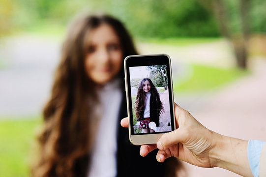 Woman taking a photo of girl with smartphone