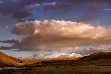 Naklejka na ściany i meble Mountain valley on the dark cloudy sky background. Altay
