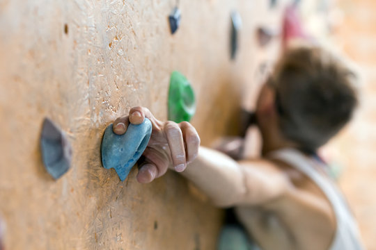 Young Female Climber on wall of indoor climbing gym