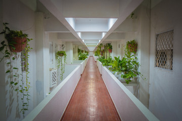 corridor of a colonial building with white walls and tiled floors