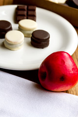 Black and white chocolate alfajores on white plate with cloth na