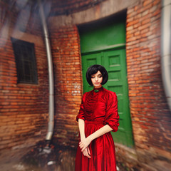 Young brunette girl in vintage romantic red dress 