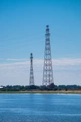 High-voltage  power lines with two towers on the river bank