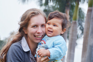 Happy mother playing with her toddler boy - biracial family