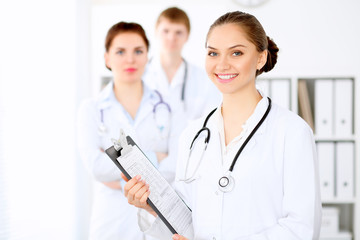 Fototapeta premium Happy doctor woman with medical staff at the hospital