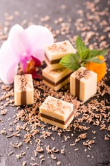 Several two colored nougat cubes on black slate stone