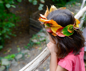 Naklejka premium Petite fille portant une couronne de feuilles mortes sur la tête