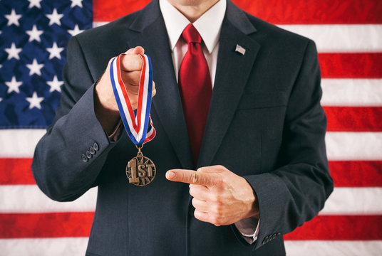 Politician: Man Holding Up A First Place Award And Pointing