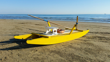 Yellow rescue boat on Italian beach. Adriatic sea.