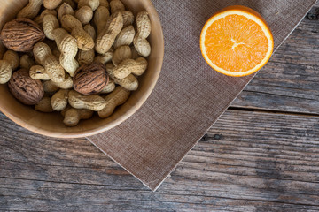 Nüsse und Orange auf rustikalem Holztisch