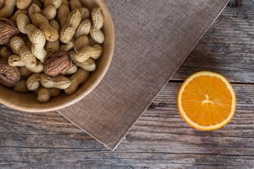 Nüsse und Orange auf rustikalem Holztisch