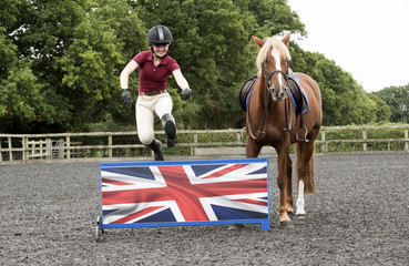 A young pony rider jumping a low fence - September 2016 - A Chestnut pony watches as the rider...