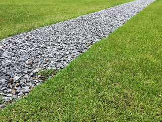 Gray gravel walking path in a grass field/lawn