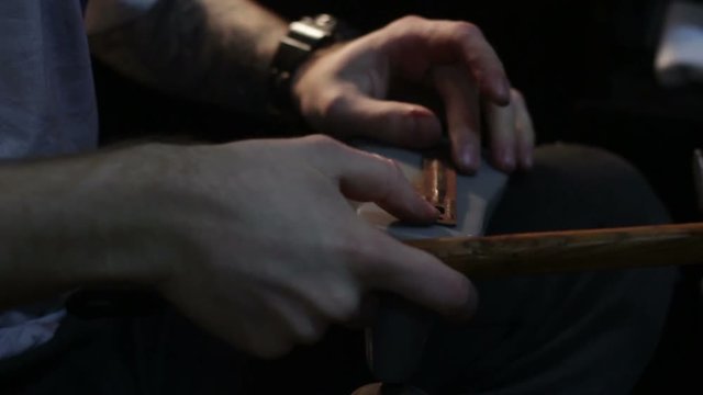 Shoemaker sews shoes, hammering sole