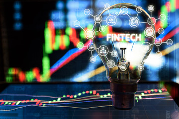 Fintech Investment Financial Internet Technology Concept. Light bulb on tablet and Stock graph and business technology icon with abstract stock graph and electronic circuit background , copy space