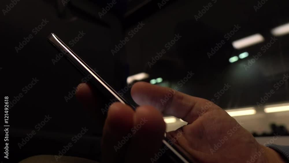 Poster man using his smartphone in the train. tapping on device touchscreen. 4k closeup video