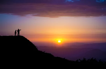  Evening landscape. Silhouettes of two people standing on a rock and looking toward the sun. Sunset in the mountains. Purple light. Summer in the Ukrainian Carpathians. With vignetting effect © oleksandrmazur