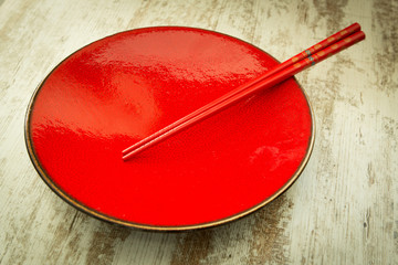 Oriental ceramic plate and chopsticks in red