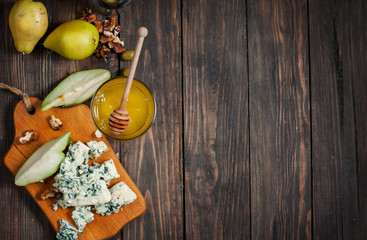 Blue cheese with honey, olive and pears on rustic table. Text place