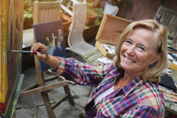 femme senior artiste peintre peignant tableau en peinture à l'huile en extérieur