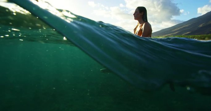 Beautiful surfer girl enjoying sunset surf in slow motion